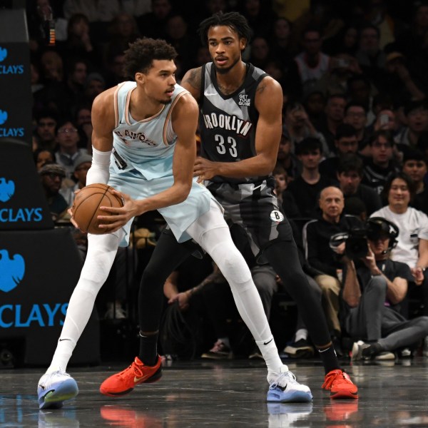 San Antonio Spurs' Victor Wembanyama, left, defends the ball from Brooklyn Nets' Nic Claxton, right, during the first half of an NBA basketball game Friday, Dec. 27, 2024, in New York. (AP Photo/Pamela Smith)