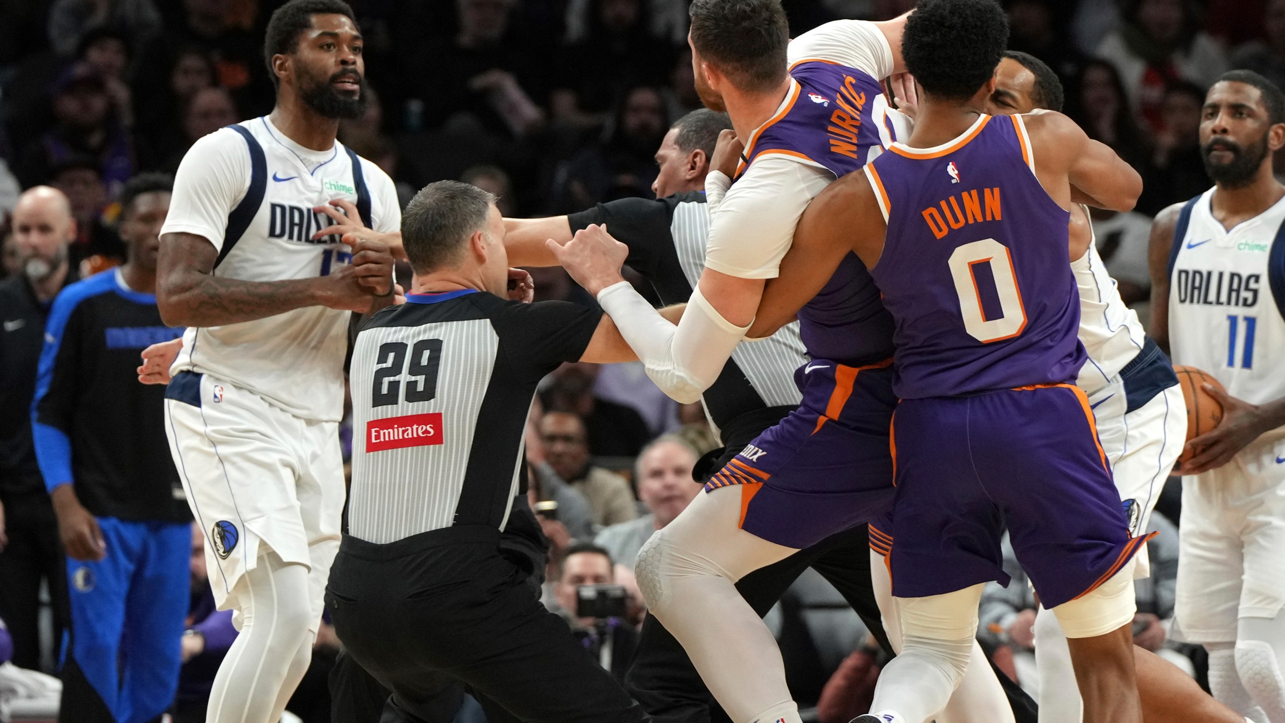 Dallas Mavericks forward Naji Marshall, left, and Phoenix Suns center Jusuf Nurkic have to be separated after fighting during the second half of an NBA basketball game, Friday, Dec. 27, 2024, in Phoenix. Dallas won 98-89. (AP Photo/Rick Scuteri)