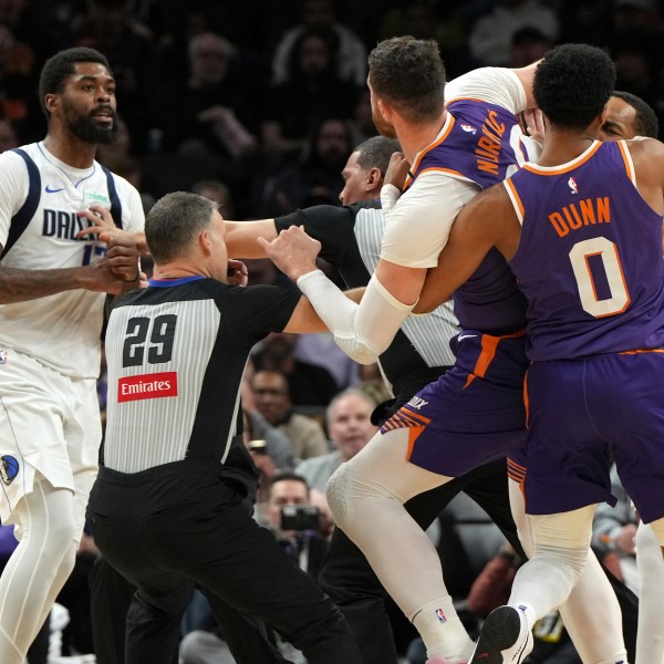 Dallas Mavericks forward Naji Marshall, left, and Phoenix Suns center Jusuf Nurkic have to be separated after fighting during the second half of an NBA basketball game, Friday, Dec. 27, 2024, in Phoenix. Dallas won 98-89. (AP Photo/Rick Scuteri)