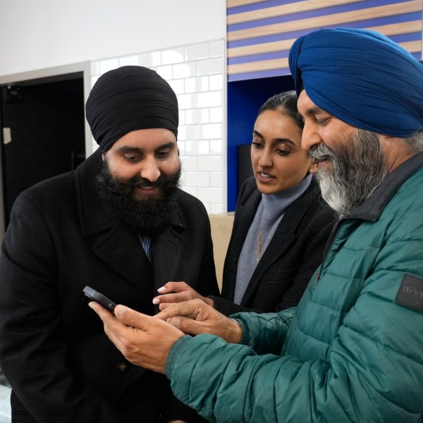 Ishar Gill, left, his sister Verdeen Gill, center and father Jaspal Singh. right, look over congratulatory texts for selling winning the Mega-Million lotto ticket worth an estimated $1.22 billion at the family's store in Cottonwood, Calif., Saturday, Dec. 28, 2024. After three months without anyone winning the top prize in the lottery, the ticket with the winning numbers was drawn Friday night.(AP Photo/Rich Pedroncelli).