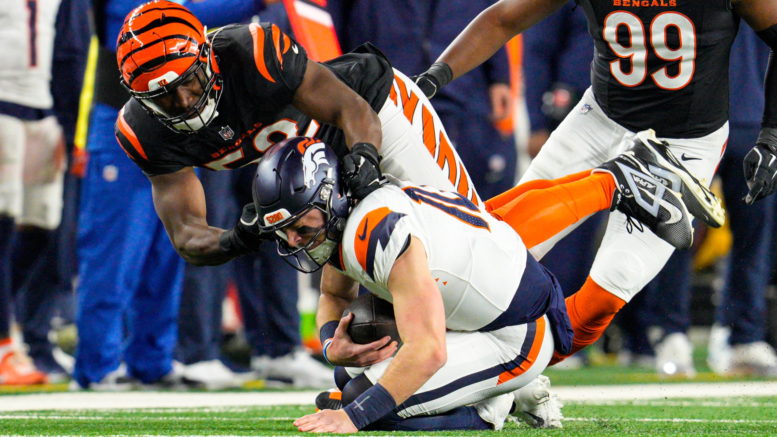 Cincinnati Bengals defensive end Cedric Johnson (52) sacks Denver Broncos quarterback Bo Nix (10) during the first half of an NFL football game in Cincinnati, Saturday, Dec. 28, 2024. (AP Photo/Jeff Dean)