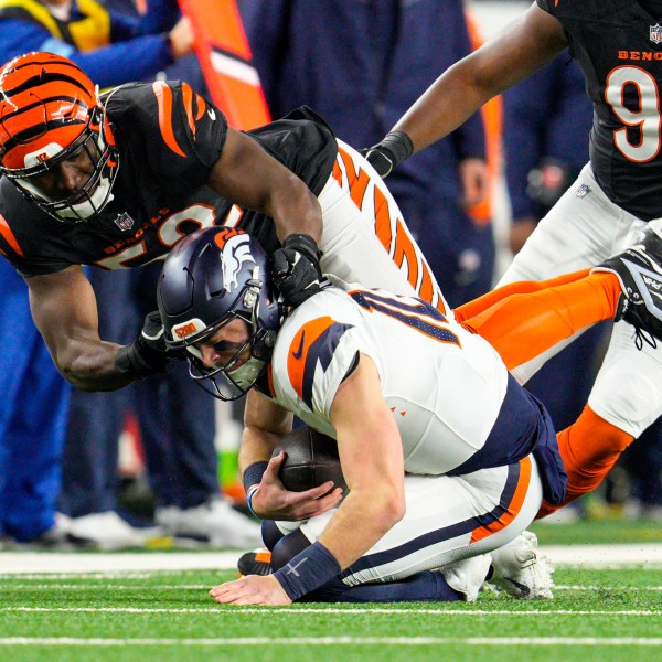 Cincinnati Bengals defensive end Cedric Johnson (52) sacks Denver Broncos quarterback Bo Nix (10) during the first half of an NFL football game in Cincinnati, Saturday, Dec. 28, 2024. (AP Photo/Jeff Dean)