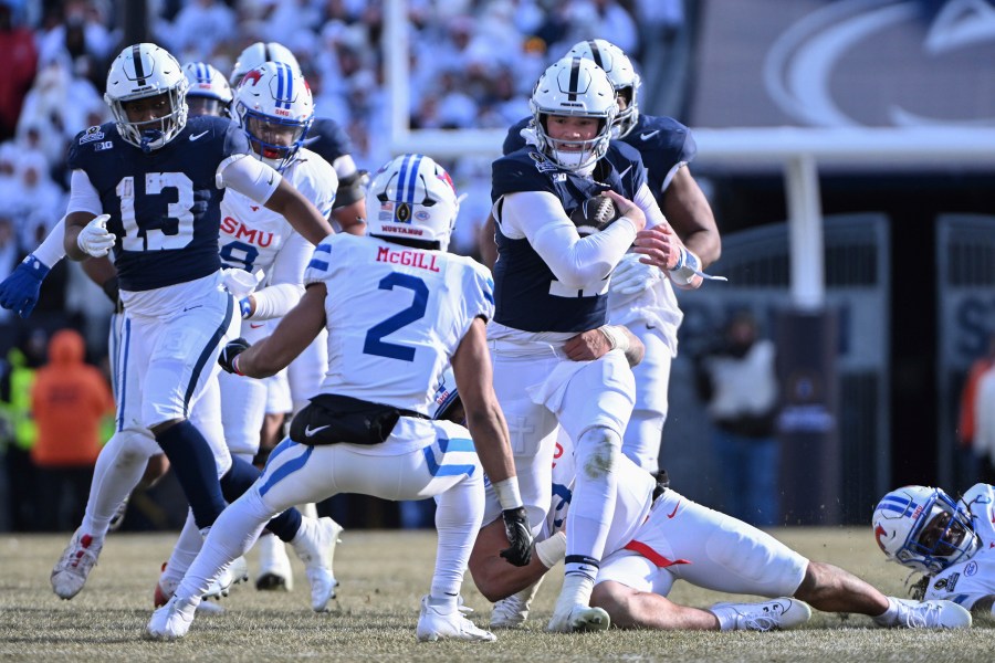 Penn State quarterback Drew Allar (15) looks to elude SMU safety Jonathan McGill (2) during the first half in the first round of the NCAA College Football Playoff, Saturday, Dec. 21, 2024, in State College, Pa. (AP Photo/Barry Reeger)