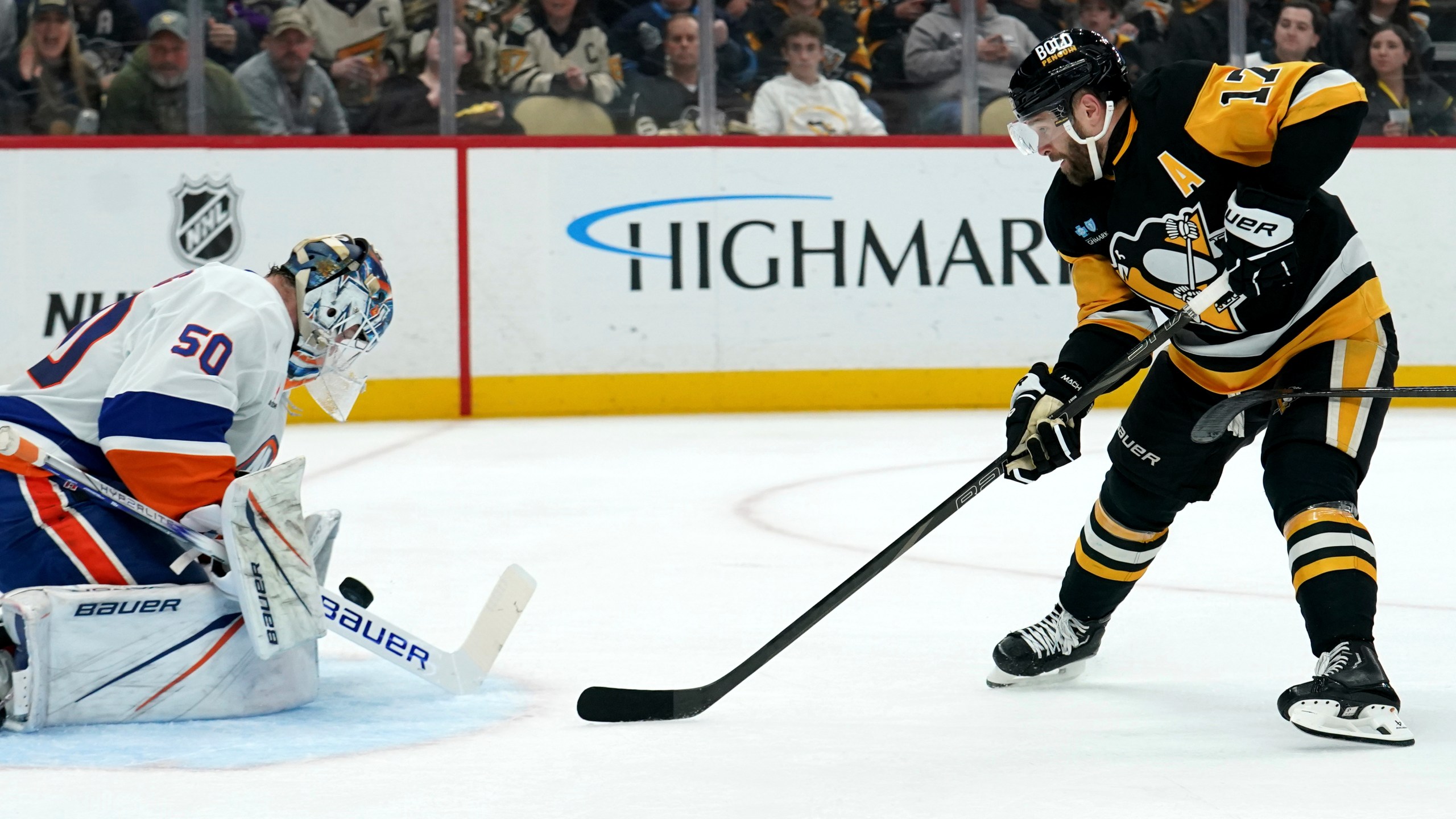 New York Islanders goaltender Marcus Hogberg (50) makes a save against Pittsburgh Penguins' Bryan Rust (17) during the second period of an NHL hockey game Sunday, Dec. 29, 2024, in Pittsburgh. (AP Photo/Matt Freed)