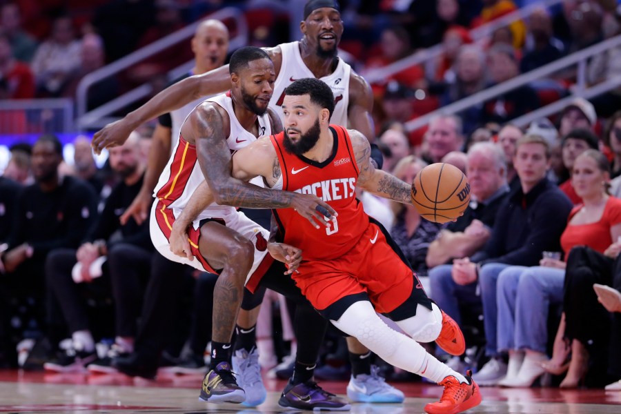 Houston Rockets guard Fred VanVleet (5) drives around Miami Heat forward Haywood Highsmith, left, as center Bam Adebayo, back, looks on during the first half of an NBA basketball game Sunday, Dec. 29, 2024, in Houston. (AP Photo/Michael Wyke)