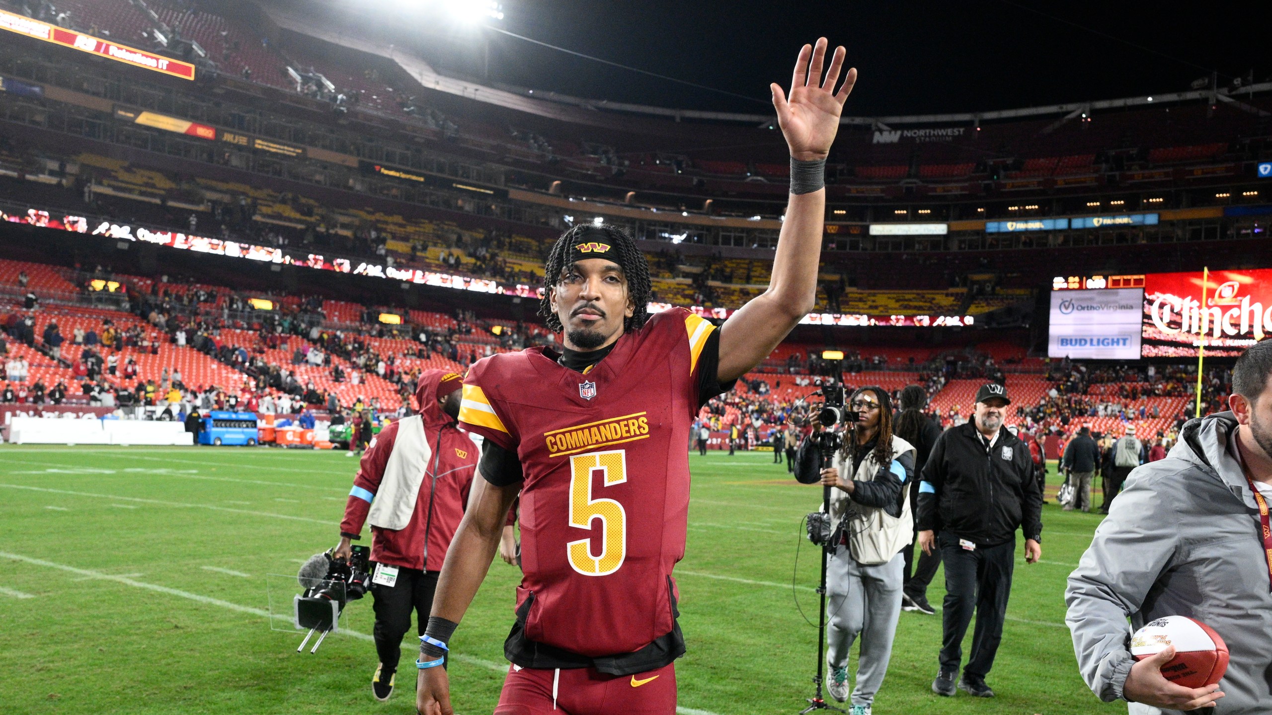 Washington Commanders quarterback Jayden Daniels (5) waves to the crowd after an overtime victory over the Atlanta Falcons during an NFL football game, Sunday, Dec. 29, 2024, in Landover, Md. The Commanders won 30-24. (AP Photo/Nick Wass)