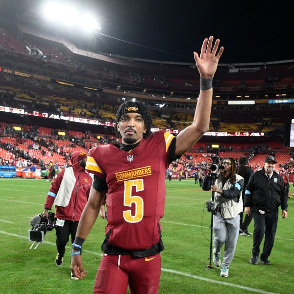 Washington Commanders quarterback Jayden Daniels (5) waves to the crowd after an overtime victory over the Atlanta Falcons during an NFL football game, Sunday, Dec. 29, 2024, in Landover, Md. The Commanders won 30-24. (AP Photo/Nick Wass)