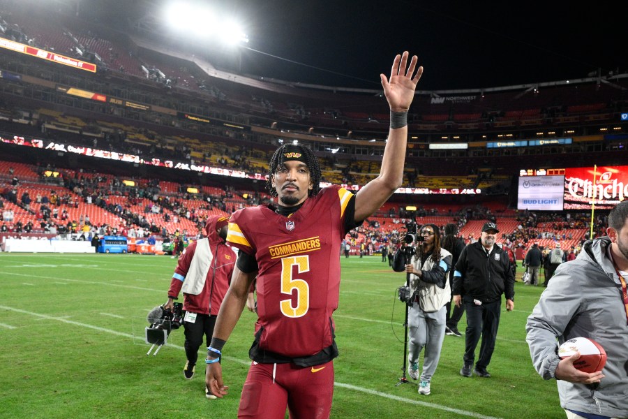 Washington Commanders quarterback Jayden Daniels (5) waves to the crowd after an overtime victory over the Atlanta Falcons during an NFL football game, Sunday, Dec. 29, 2024, in Landover, Md. The Commanders won 30-24. (AP Photo/Nick Wass)