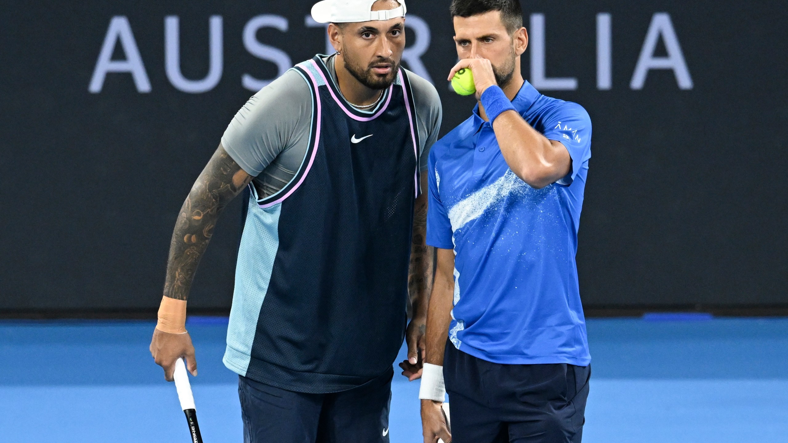 Australia's Nick Kyrgios, left, talks with Serbia's Novak Djokovic during their doubles match against Alexander Erler of Austria and Andreas Mies of Germany in the Brisbane International, at the Queensland Tennis Centre in Brisbane, Australia, Monday, Dec. 30, 2024. (Darren England/AAP Image via AP)