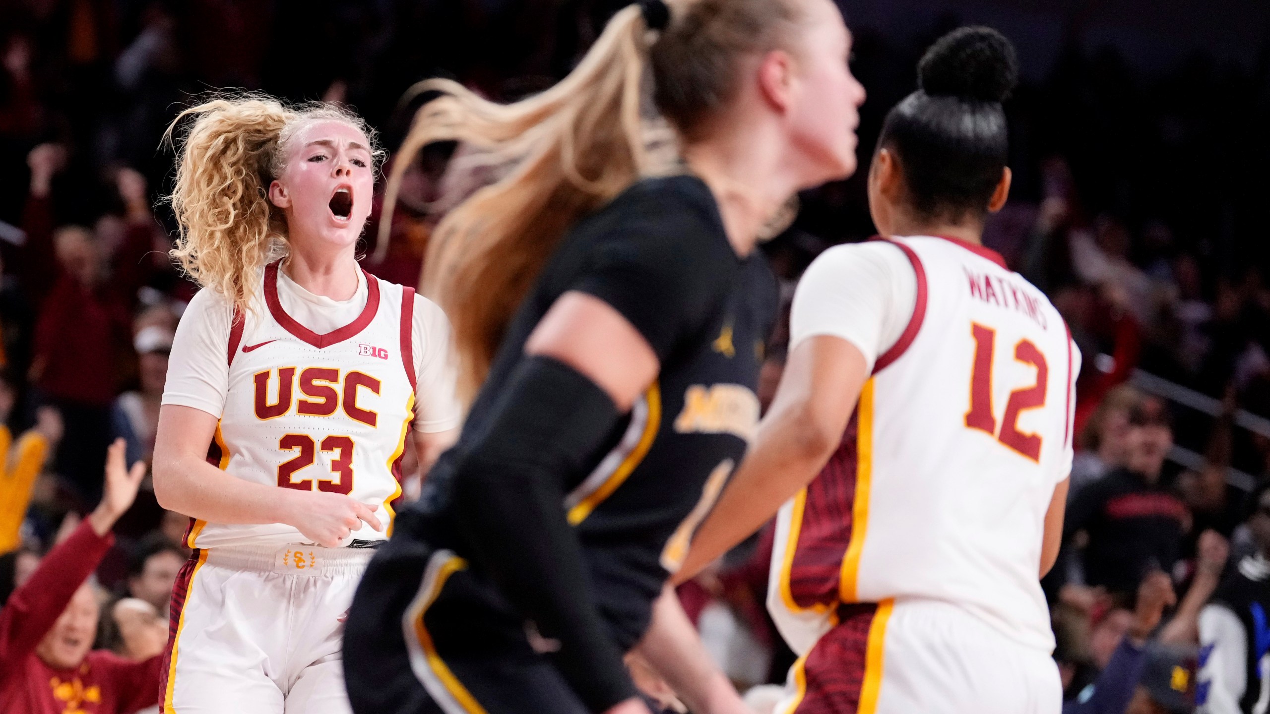 Southern California guard Avery Howell, left, celebrates after scoring with guard JuJu Watkins, right, as Michigan guard Olivia Olson walks away during the second half of an NCAA college basketball game, Sunday, Dec. 29, 2024, in Los Angeles. (AP Photo/Mark J. Terrill)