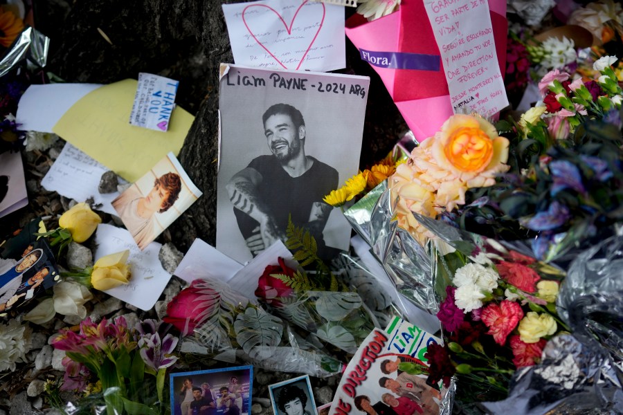 FILE - A picture of former One Direction singer Liam Payne sits surrounded by flowers and candles as fans gather outside the hotel where he was found dead after falling from a balcony in Buenos Aires, Argentina, Oct. 17, 2024. (AP Photo/Natacha Pisarenko, File)