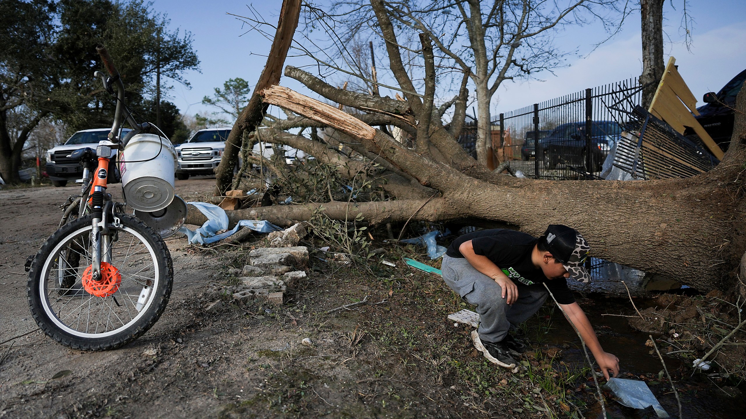 J.C. Betanzos, 11, looks for items from his sister's business and things his deceased mother gave them that blew away during a tornado, Saturday, Dec. 28, 2024, in Katy, Texas. (Elizabeth Conley/Houston Chronicle via AP)