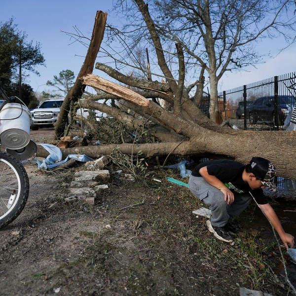 J.C. Betanzos, 11, looks for items from his sister's business and things his deceased mother gave them that blew away during a tornado, Saturday, Dec. 28, 2024, in Katy, Texas. (Elizabeth Conley/Houston Chronicle via AP)