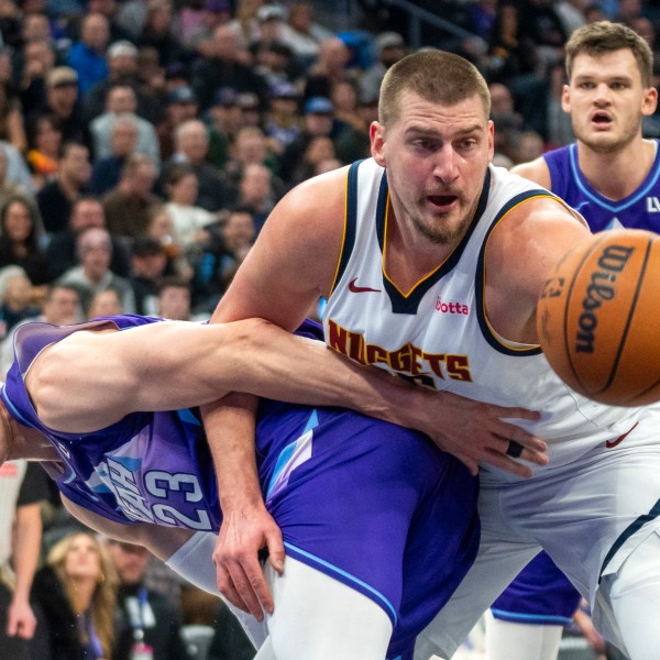 Denver Nuggets center Nikola Jokic, front right, becomes entangled with Utah Jazz forward Lauri Markkanen (23) as Jazz center Walker Kessler, back right, looks on during the first half of an NBA basketball game Monday, Dec. 30, 2024, in Salt Lake City. (AP Photo/Rick Egan)