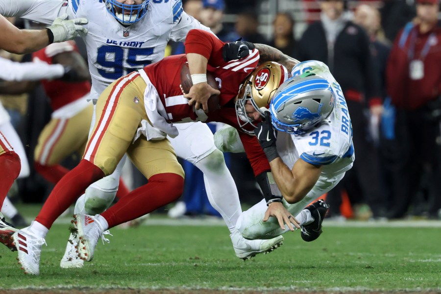 San Francisco 49ers quarterback Brock Purdy (13) is tackled by Detroit Lions safety Brian Branch (32) during the second half of an NFL football game Monday, Dec. 30, 2024, in Santa Clara, Calif. (AP Photo/Jed Jacobsohn)