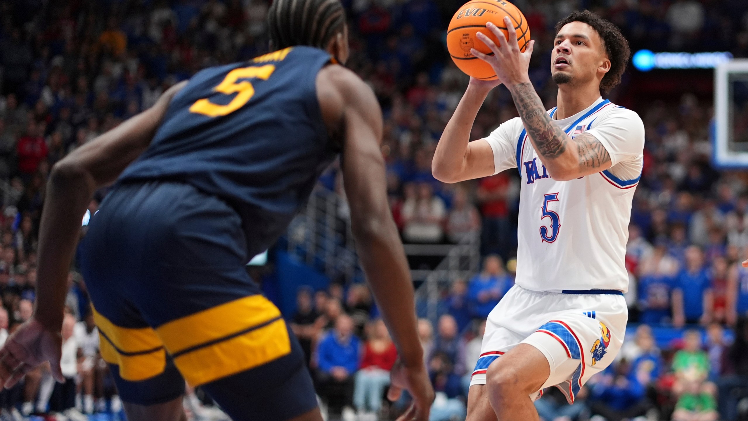 Kansas guard Zeke Mayo (5) looks to shoot during the first half of an NCAA college basketball game against West Virginia, Tuesday, Dec. 31, 2024, in Lawrence, Kan. (AP Photo/Charlie Riedel)