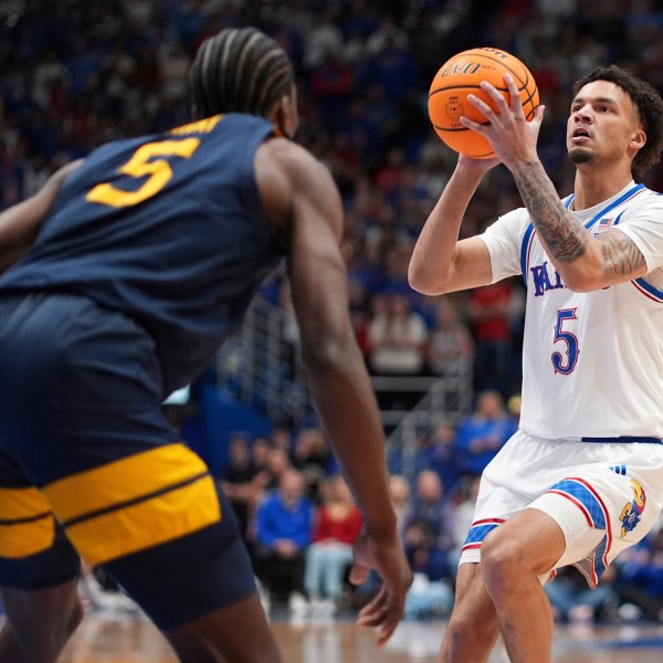 Kansas guard Zeke Mayo (5) looks to shoot during the first half of an NCAA college basketball game against West Virginia, Tuesday, Dec. 31, 2024, in Lawrence, Kan. (AP Photo/Charlie Riedel)