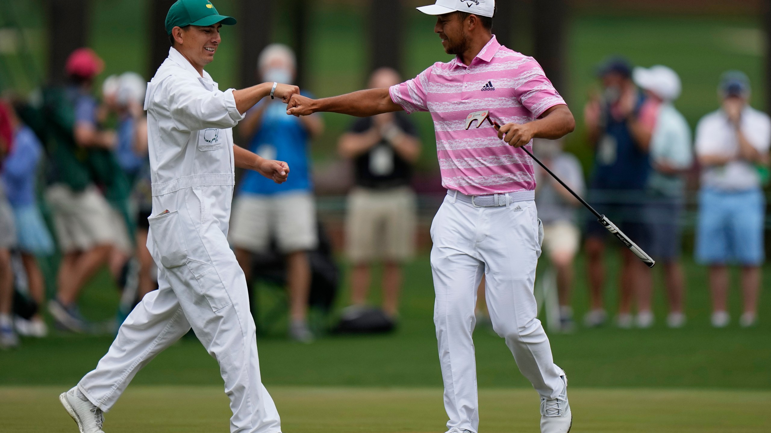 FILE - Xander Schauffele is congratulated by his caddie Austin Kaiser after an eagle on the 15th hole during the third round of the Masters golf tournament on Saturday, April 10, 2021, in Augusta, Ga. (AP Photo/Matt Slocum, File)