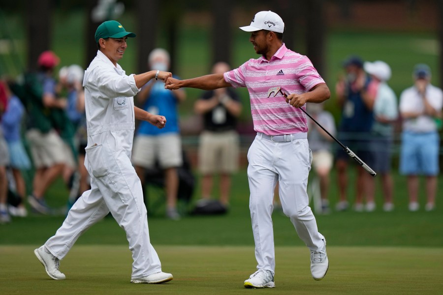 FILE - Xander Schauffele is congratulated by his caddie Austin Kaiser after an eagle on the 15th hole during the third round of the Masters golf tournament on Saturday, April 10, 2021, in Augusta, Ga. (AP Photo/Matt Slocum, File)