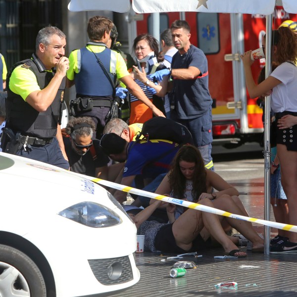 FILE - Injured people are treated in Barcelona, Spain, Thursday, Aug. 17, 2017 after a white van jumped the sidewalk in the historic Las Ramblas district, crashing into a summer crowd of residents and tourists. (AP Photo/Oriol Duran, File)