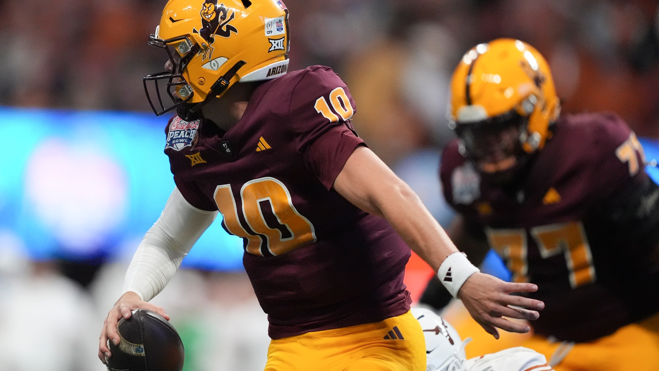 Arizona State quarterback Sam Leavitt (10) runs out of the pocket against Texas during the first half in the quarterfinals of a College Football Playoff, Wednesday, Jan. 1, 2025, in Atlanta. (AP Photo/Brynn Anderson)