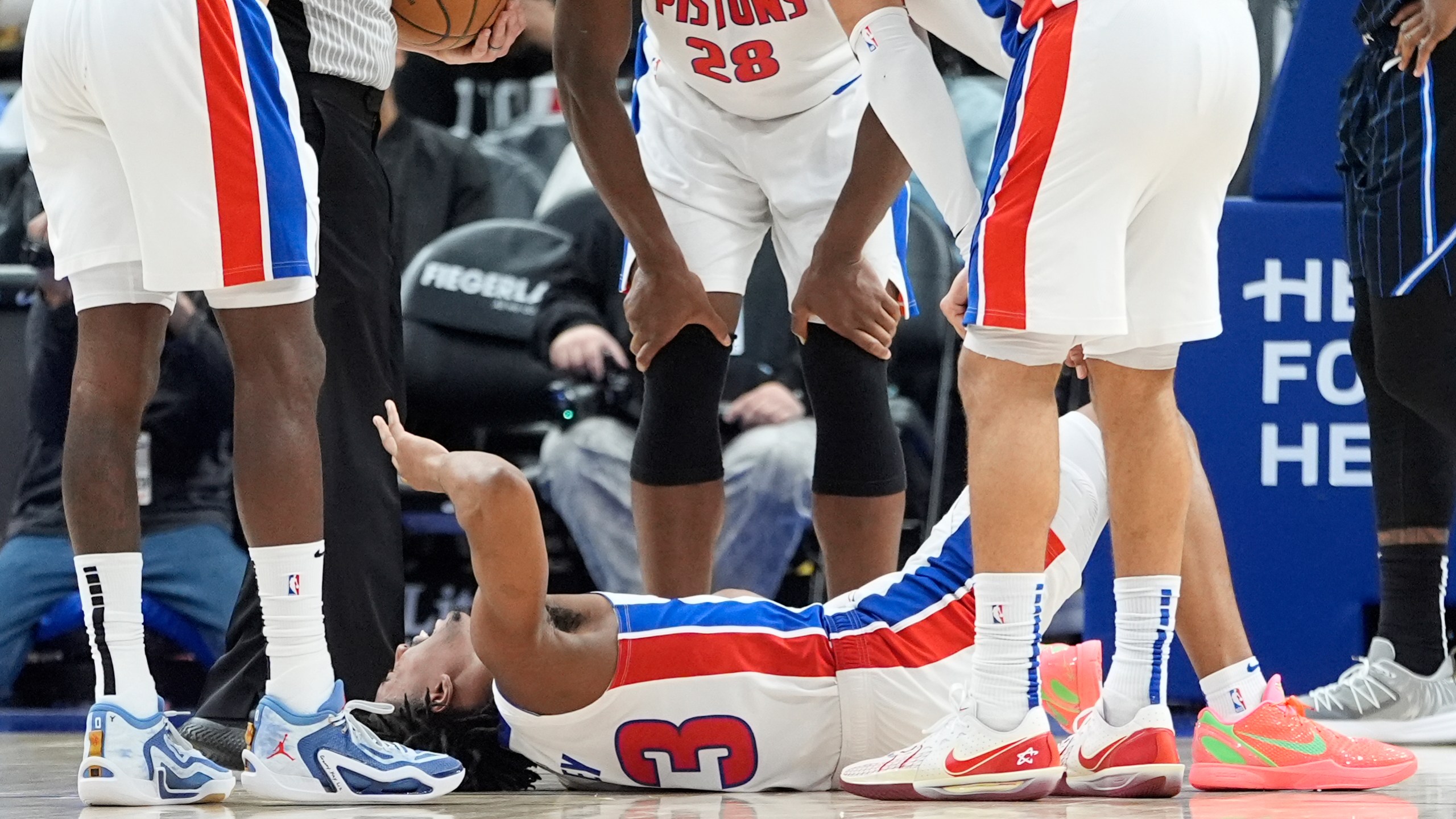 Teammates look over Detroit Pistons guard Jaden Ivey (23) after an incident during the second half of an NBA basketball game against the Orlando Magic, Wednesday, Jan. 1, 2025, in Detroit. (AP Photo/Carlos Osorio)