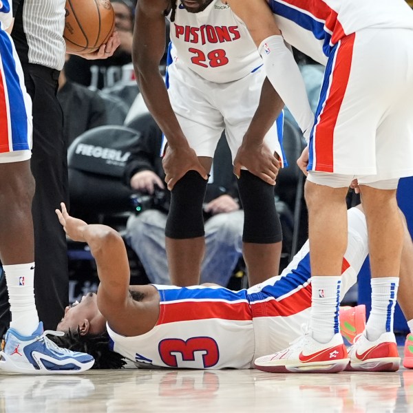 Teammates look over Detroit Pistons guard Jaden Ivey (23) after an incident during the second half of an NBA basketball game against the Orlando Magic, Wednesday, Jan. 1, 2025, in Detroit. (AP Photo/Carlos Osorio)