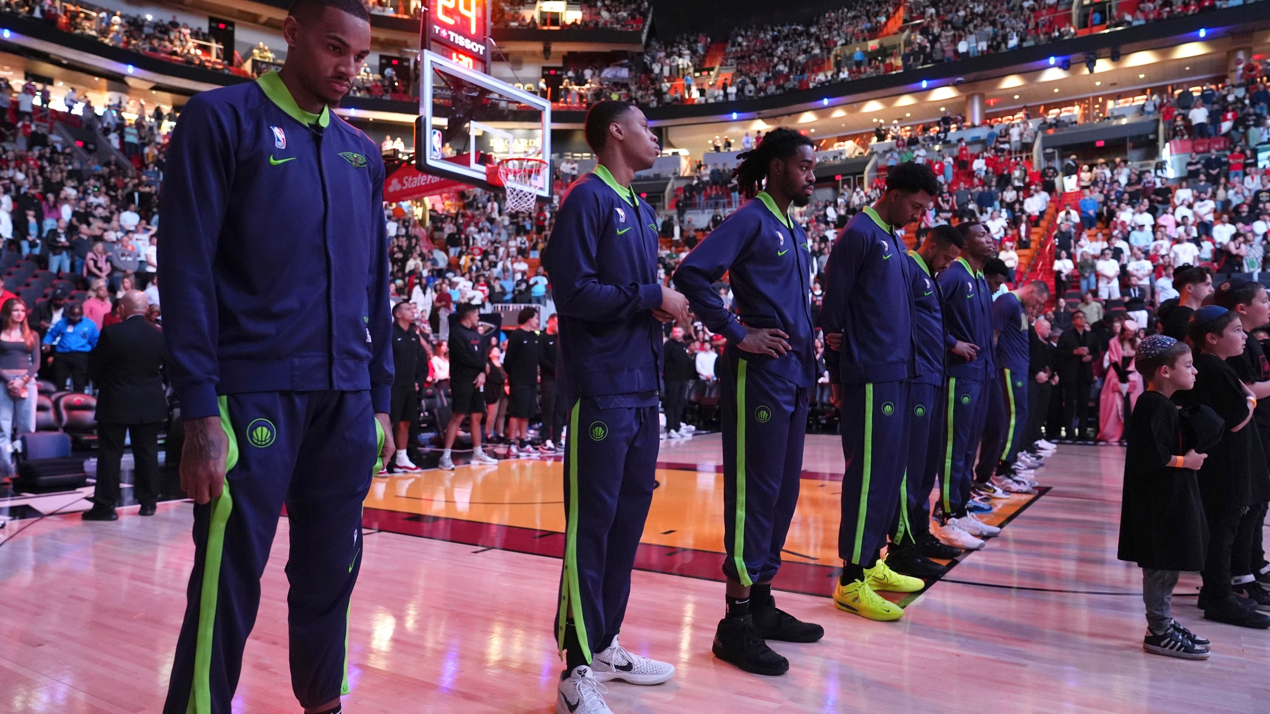 New Orleans Pelicans players stand during a tribute at the Kaseya Center for people killed after a vehicle drove into a crowd in New Orleans before an NBA basketball game between the Miami Heat and the New Orleans Pelicans, Wednesday, Jan. 1, 2025, in Miami. (AP Photo/Lynne Sladky)