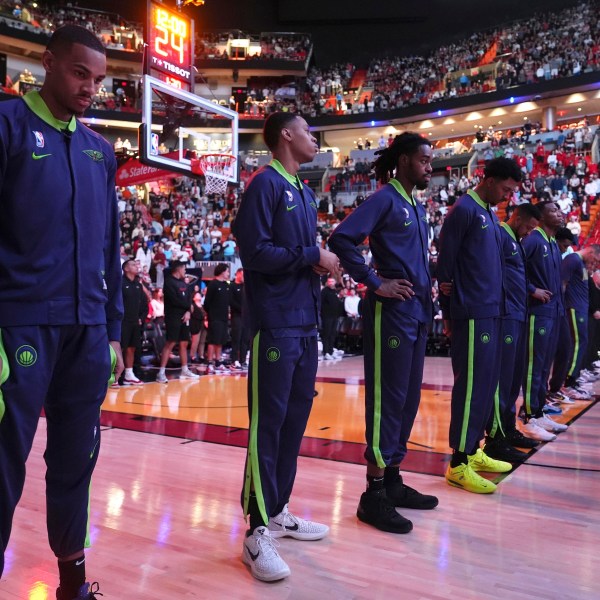 New Orleans Pelicans players stand during a tribute at the Kaseya Center for people killed after a vehicle drove into a crowd in New Orleans before an NBA basketball game between the Miami Heat and the New Orleans Pelicans, Wednesday, Jan. 1, 2025, in Miami. (AP Photo/Lynne Sladky)