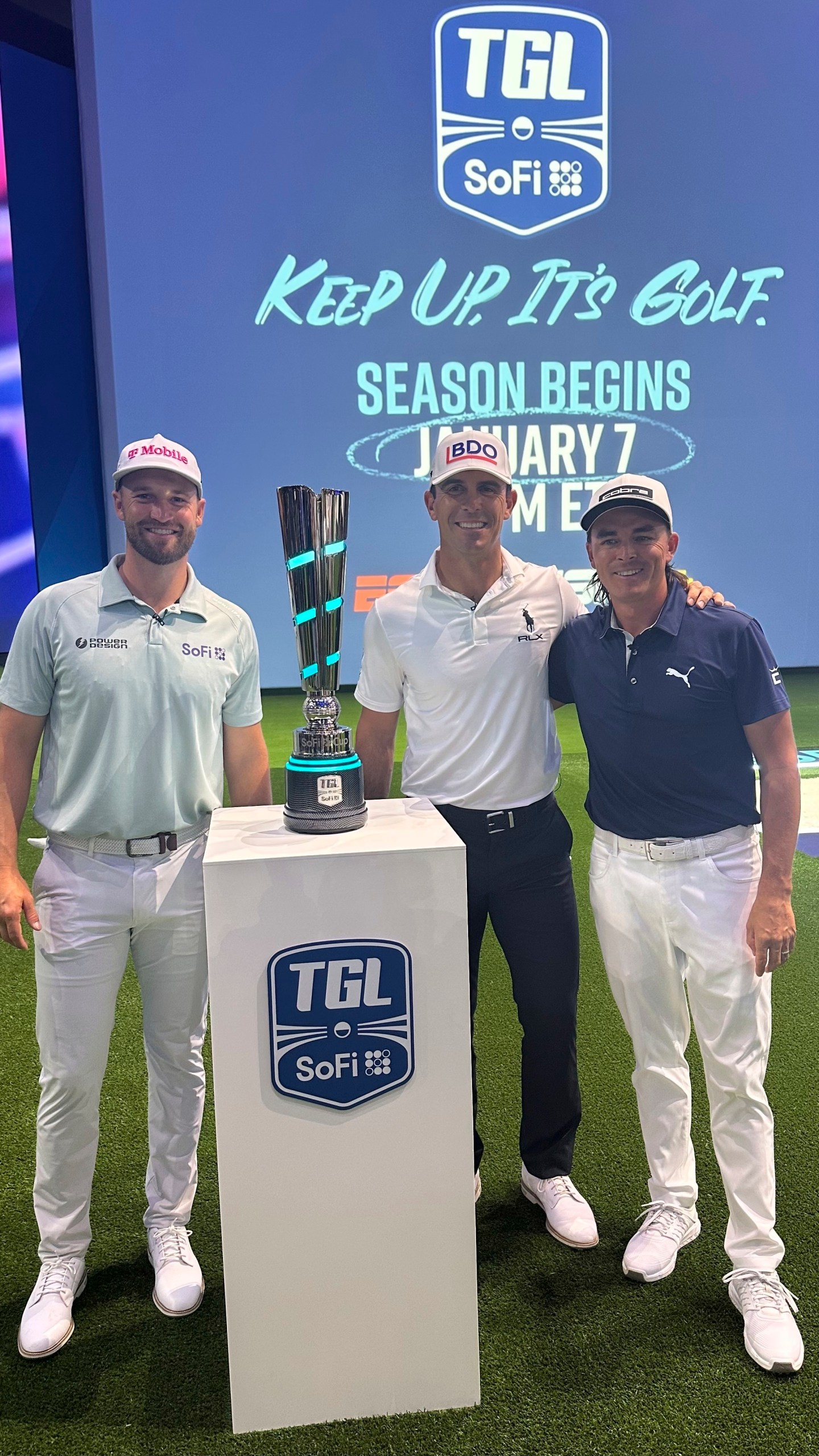 Wyndham Clark, left, Billy Horschel, center, and Rickie Fowler pose with the SoFi Cup on Wednesday, Dec. 18, 2024, in Palm Beach Gardens, Fla. The trophy goes to the winner of six teams competing in the new TMRW Golf League held in a tech-infused indoor arena. It debuts on Jan. 7, 2025 in prime time on ESPN. (AP Photo/Doug Ferguson)