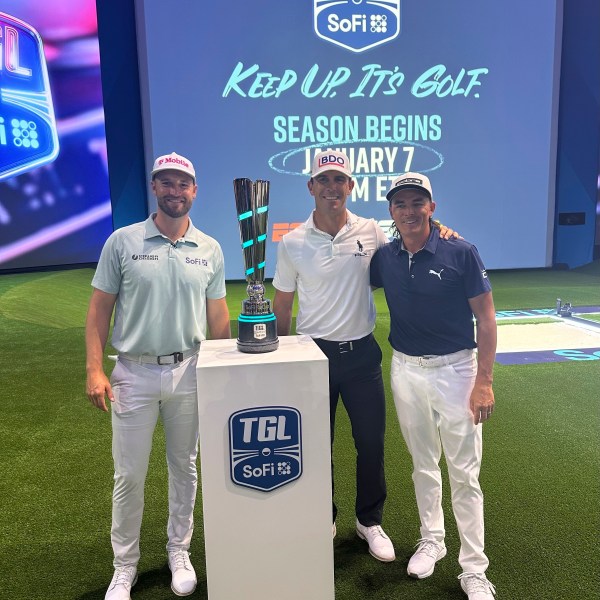 Wyndham Clark, left, Billy Horschel, center, and Rickie Fowler pose with the SoFi Cup on Wednesday, Dec. 18, 2024, in Palm Beach Gardens, Fla. The trophy goes to the winner of six teams competing in the new TMRW Golf League held in a tech-infused indoor arena. It debuts on Jan. 7, 2025 in prime time on ESPN. (AP Photo/Doug Ferguson)