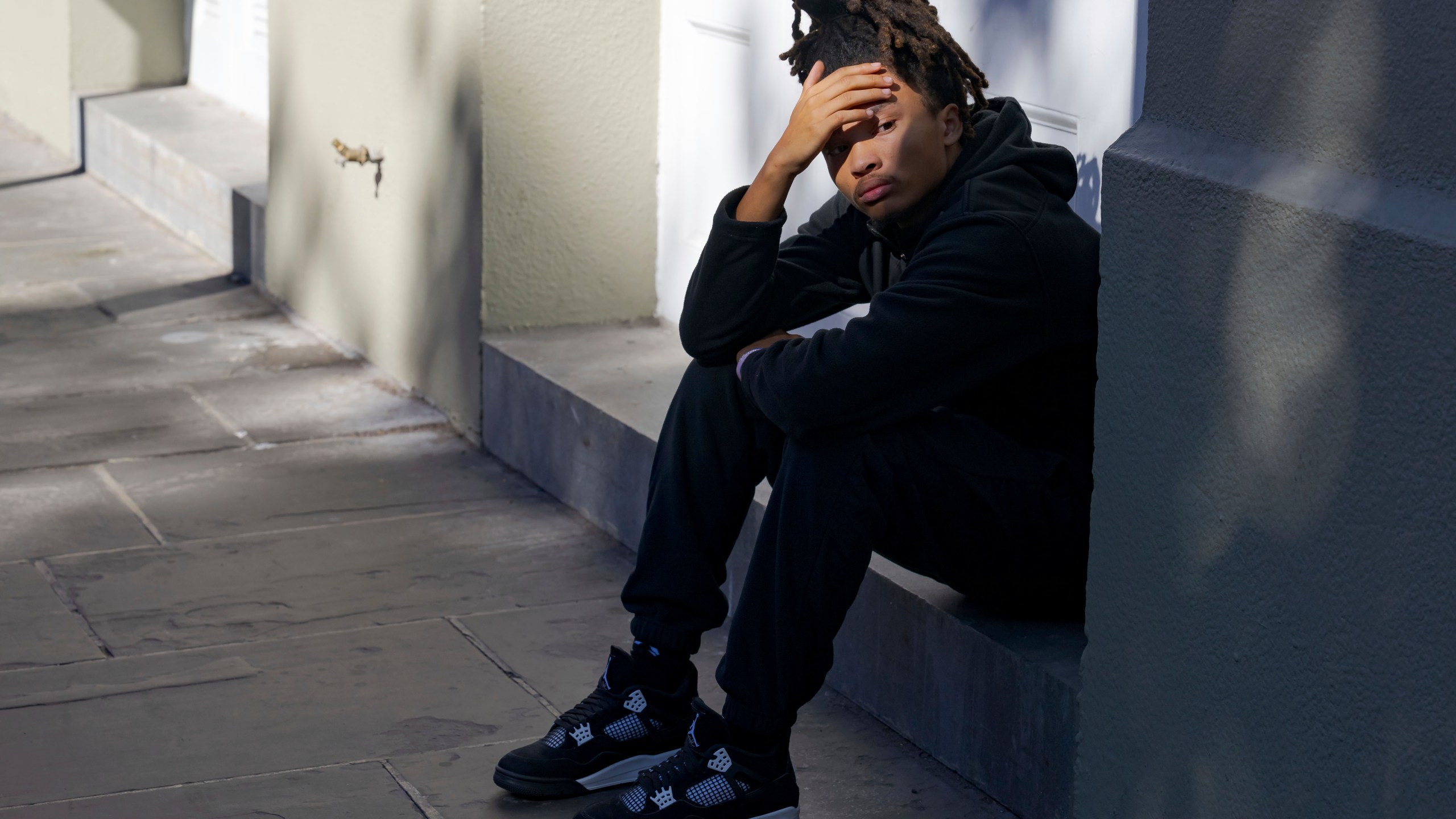 Trevant Hayes, 20, sits in the French Quarter after the death of his friend, Nikyra Dedeaux, 18, after a pickup truck crashed into pedestrians on Bourbon Street followed by a shooting in the French Quarter in New Orleans, Wednesday, Jan. 1, 2025. (AP Photo/Matthew Hinton)