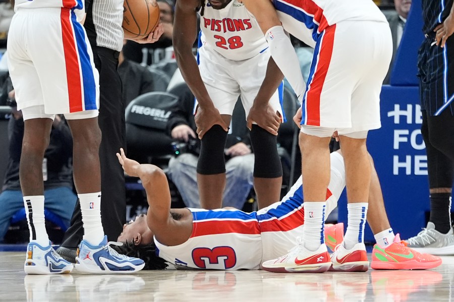 Teammates look over Detroit Pistons guard Jaden Ivey (23) after an incident during the second half of an NBA basketball game against the Orlando Magic, Wednesday, Jan. 1, 2025, in Detroit. (AP Photo/Carlos Osorio)