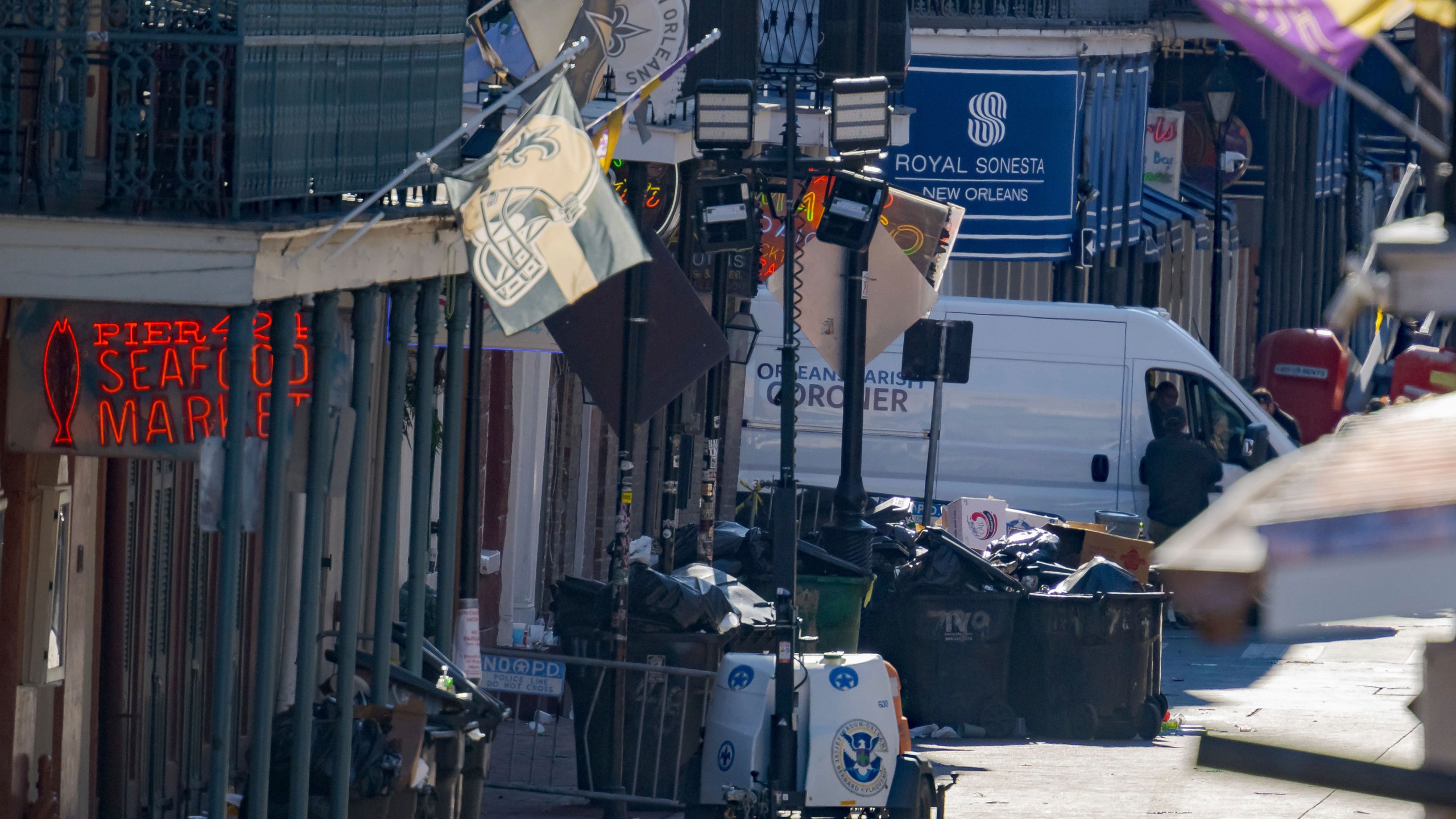 An Orleans Parish Coroner van is seen on Bourbon Street during the investigation of a pickup truck crashing into pedestrians on Bourbon Street in front of the Royal Sonesta Hotel in the French Quarter in New Orleans, Wednesday, Jan. 1, 2025. (AP Photo/Matthew Hinton)