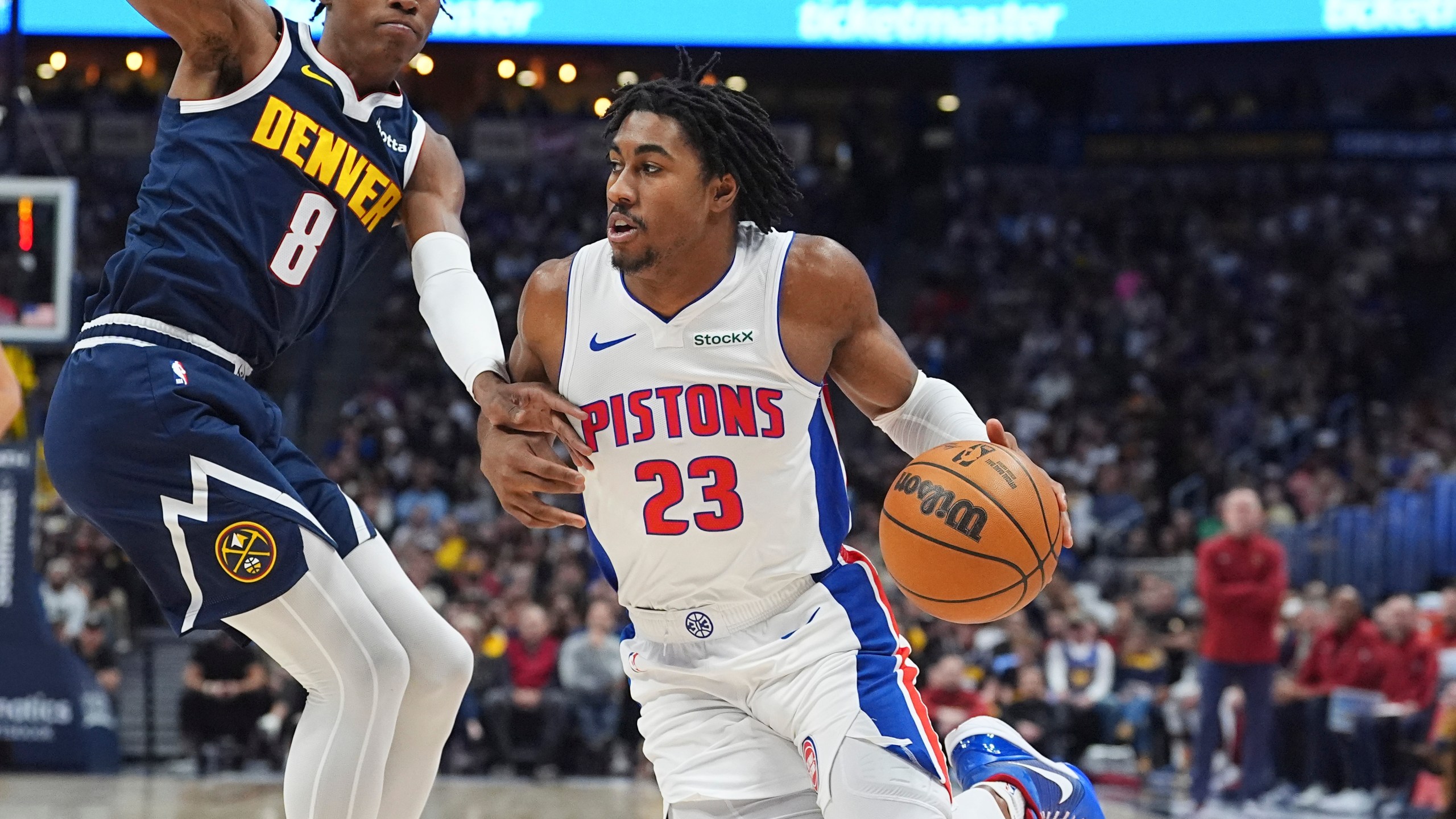 Detroit Pistons guard Jaden Ivey, right, drives to the basket as Denver Nuggets forward Peyton Watson defends in the first half of an NBA basketball game Saturday, Dec. 28, 2024, in Denver. (AP Photo/David Zalubowski)