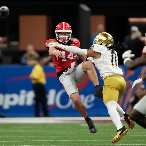 Georgia quarterback Gunner Stockton (14) throws a pass as he is pressured by Notre Dame safety Xavier Watts (0) during the second half in the quarterfinals of a College Football Playoff, Thursday, Jan. 2, 2025, in New Orleans. (AP Photo/Gerald Herbert)