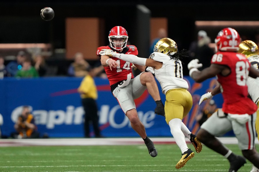 Georgia quarterback Gunner Stockton (14) throws a pass as he is pressured by Notre Dame safety Xavier Watts (0) during the second half in the quarterfinals of a College Football Playoff, Thursday, Jan. 2, 2025, in New Orleans. (AP Photo/Gerald Herbert)