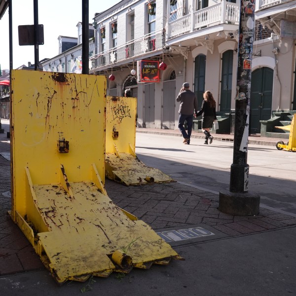 Tourist walk past temporary barriers on Bourbon Street, Thursday, Jan. 2, 2025 in New Orleans. (AP Photo/George Walker IV)