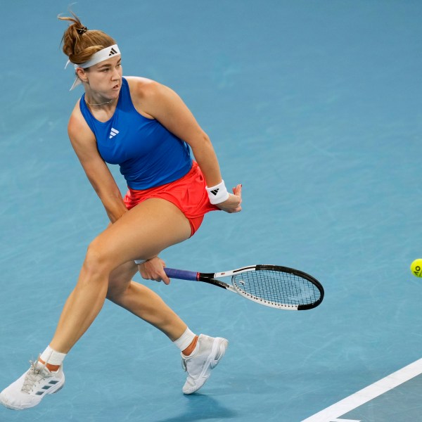 Czechia's Karolina Muchova plays a shot between her legs to Italy's Jasmine Paolini during their quarterfinal match at the United Cup tennis tournament in Sydney, Australia, Friday, Jan. 3, 2025. (AP Photo/Rick Rycroft)