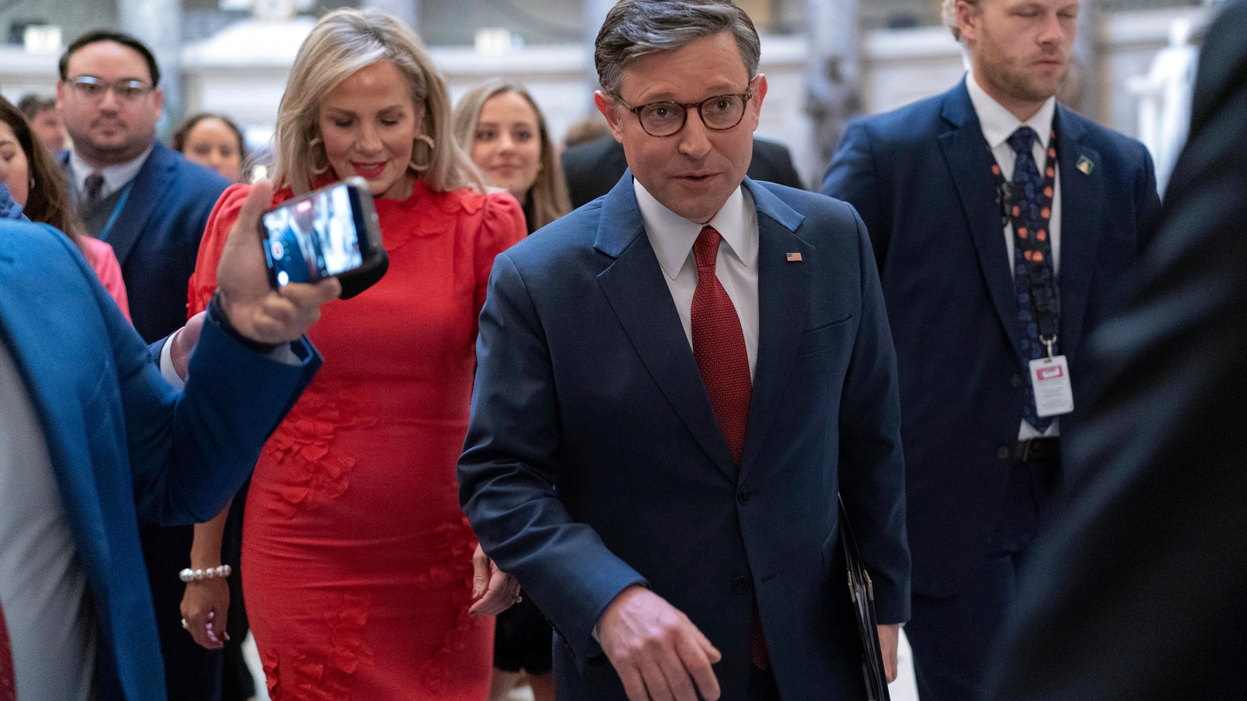 Speaker of the House Mike Johnson, R-La., accompanied by his wife Kelly Johnson, left, walks to the House Chamber before starting the 119th United States Congress at the Capitol in Washington, Friday, Jan. 3, 2025. (AP Photo/Jose Luis Magana)