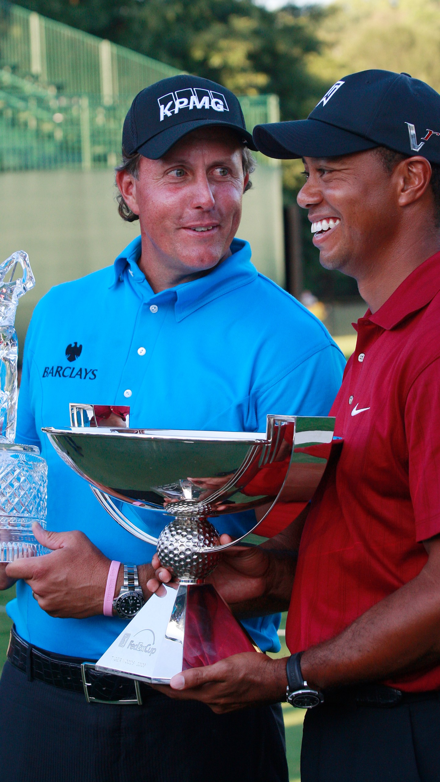 FILE - Phil Mickelson, left, and Tiger Woods pose with their trophies after the final round of The Tour Championship golf tournament at East Lake Golf Club in Atlanta Sunday, Sept. 27, 2009. Mickelson won The Tour Championship and Tiger Woods won the FedEx Cup. (AP Photo/Dave Martin)