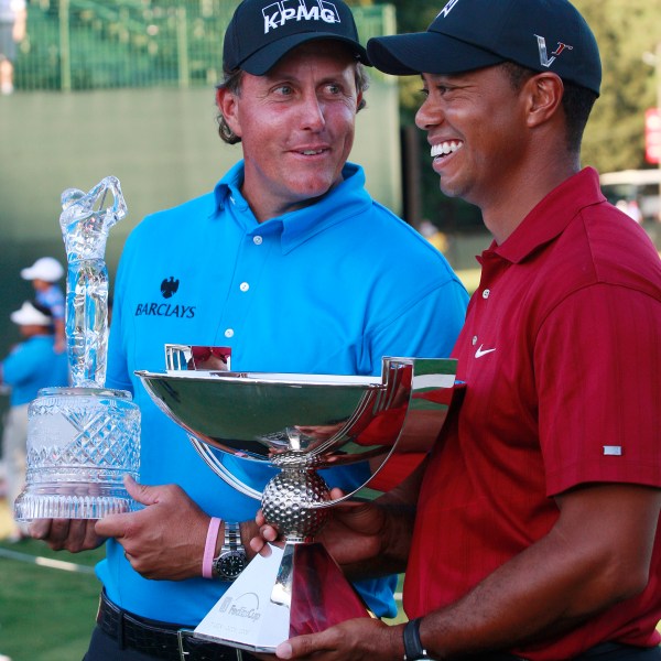 FILE - Phil Mickelson, left, and Tiger Woods pose with their trophies after the final round of The Tour Championship golf tournament at East Lake Golf Club in Atlanta Sunday, Sept. 27, 2009. Mickelson won The Tour Championship and Tiger Woods won the FedEx Cup. (AP Photo/Dave Martin)