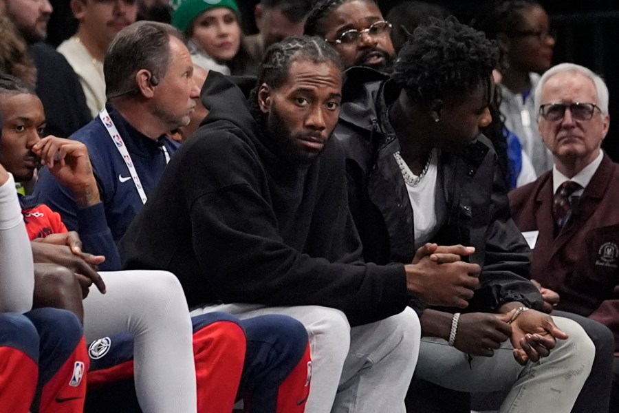 Los Angeles Clippers forward Kawhi Leonard watches from the bench during the first quarter of an NBA basketball game against the Dallas Mavericks, Saturday, Dec. 21, 2024, in Dallas. (AP Photo/LM Otero)