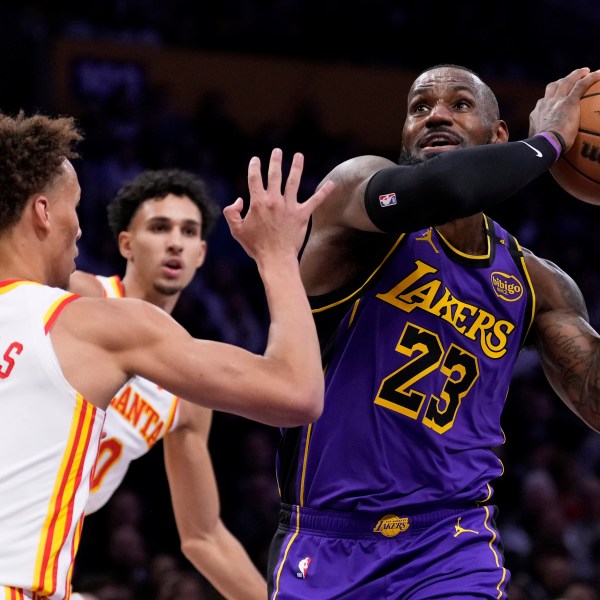 Los Angeles Lakers forward LeBron James, right, shoots as Atlanta Hawks guard Dyson Daniels defends during the first half of an NBA basketball game, Friday, Jan. 3, 2025, in Los Angeles. (AP Photo/Mark J. Terrill)