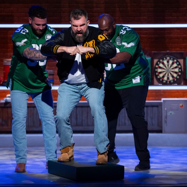 Former NFL player and ESPN analyst Jason Kelce, center, gets pushed out like an old electronic football player during the taping of "They Call It Late Night with Jason Kelce", Friday, Jan. 3, 2025, in Philadelphia. (AP Photo/Chris Szagola)