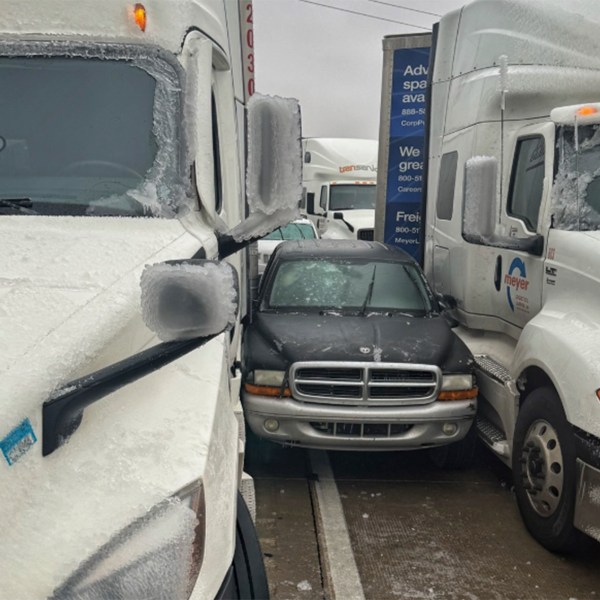 In a photo released by the Kansas Highway Patrol, a car is wedged between two trucks during icy weather Saturday, Jan. 4, 2024, in Salina, Kansas. (Kansas Highway Patrol via AP)