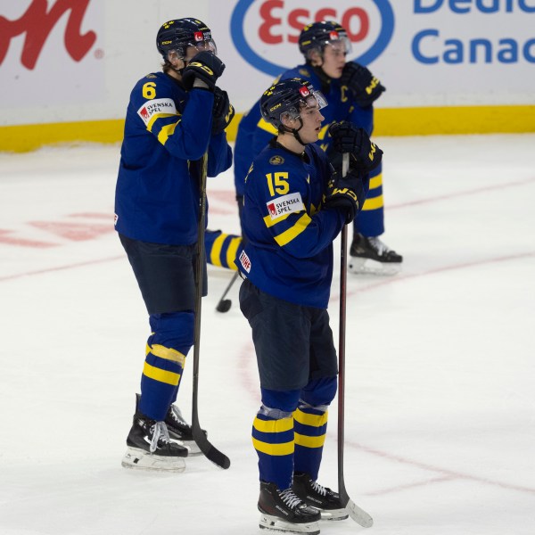 Sweden forward David Edstrom (15) and teammates Axel Hurtig (6) and Axel Sandin Pellikka react after losing in overtime against Finland in semifinal game at the world junior hockey championship, Saturday, Jan. 4, 2025 in Ottawa, Ontario. (Adrian Wyld/The Canadian Press via AP)