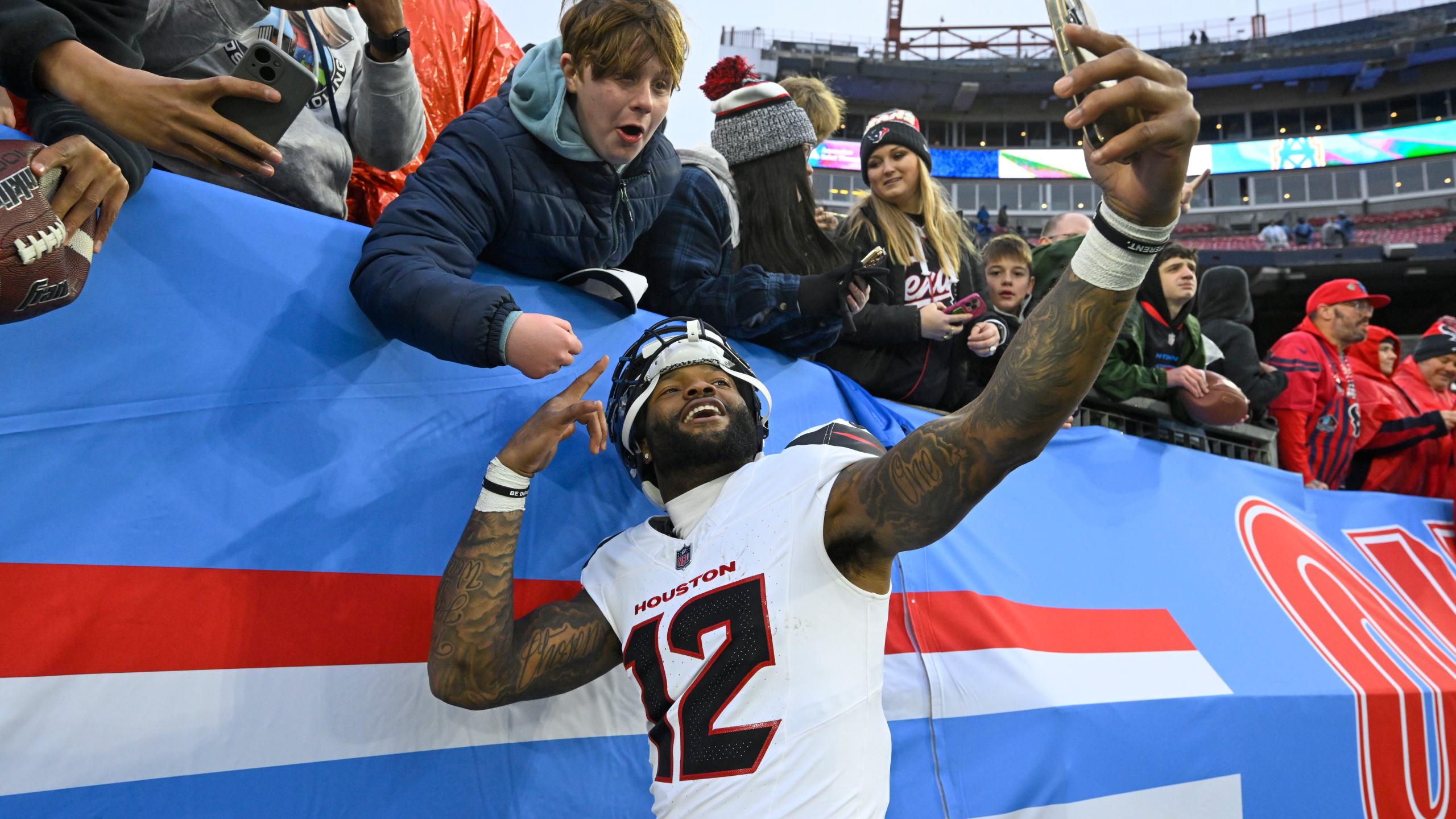 Houston Texans wide receiver Nico Collins (12) celebrates with a fan after an NFL football game against the Tennessee Titans Sunday, Jan. 5, 2025, in Nashville, Tenn. The Texans won 23-14. (AP Photo/John Amis)