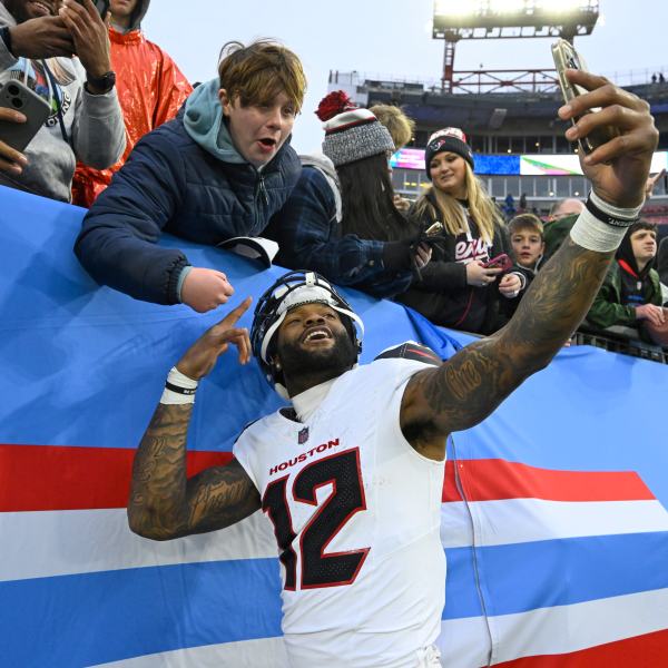 Houston Texans wide receiver Nico Collins (12) celebrates with a fan after an NFL football game against the Tennessee Titans Sunday, Jan. 5, 2025, in Nashville, Tenn. The Texans won 23-14. (AP Photo/John Amis)