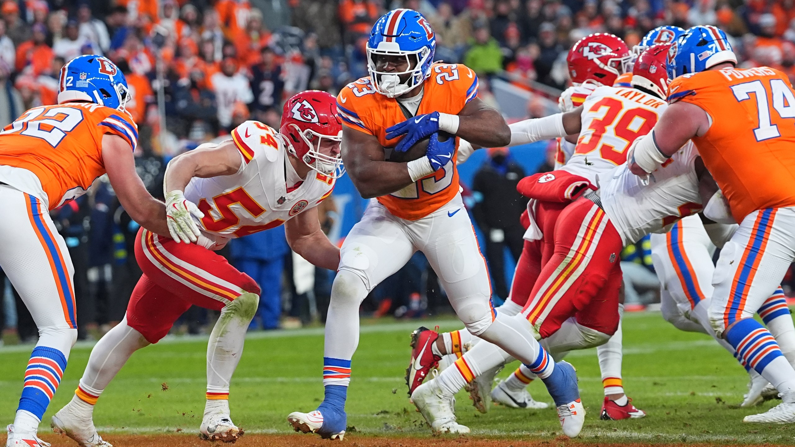 Denver Broncos running back Audric Estime (23) scores past Kansas City Chiefs linebacker Leo Chenal (54) during the second half of an NFL football game Sunday, Jan. 5, 2025, in Denver. (AP Photo/David Zalubowski)